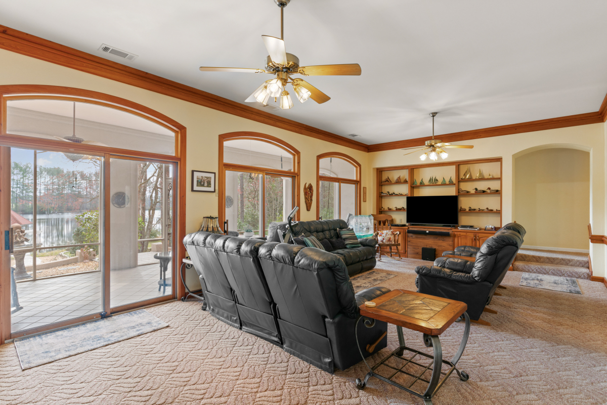 Open-concept living area with custom built-ins, granite countertops, and large windows with lake views