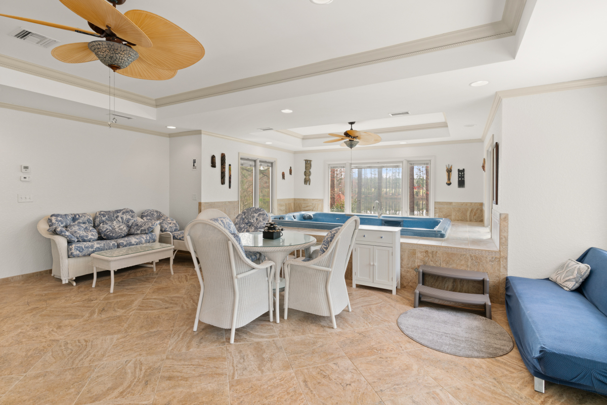 Indoor swim spa with lounge area and panoramic views of the stocked lake