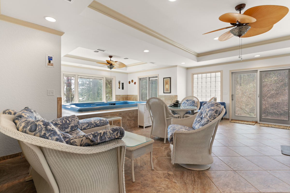 Indoor swim spa with lounge area and panoramic views of the stocked lake