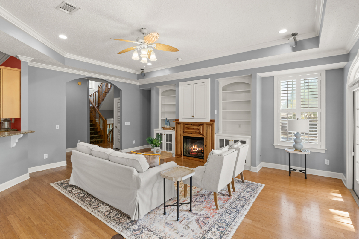 Open living room with fireplace and custom built-ins in home for sale in Hampton Plantation
