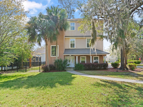Three-story home for sale in Hampton Plantation St Simons Island GA with fenced yard and mature landscaping
