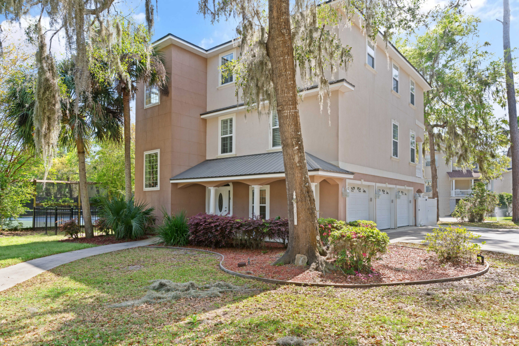 Three-story home for sale in Hampton Plantation St Simons Island GA with fenced yard and mature landscaping