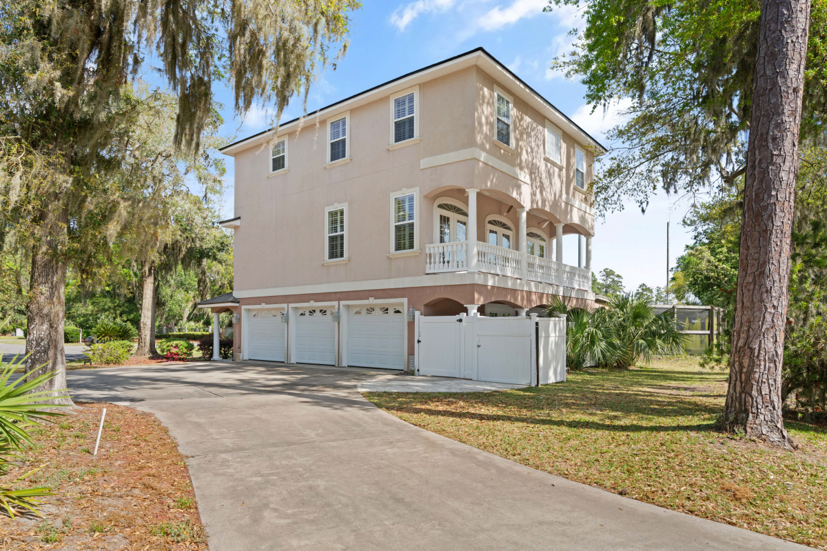 Three-story home for sale in Hampton Plantation St Simons Island GA with fenced yard and mature landscaping