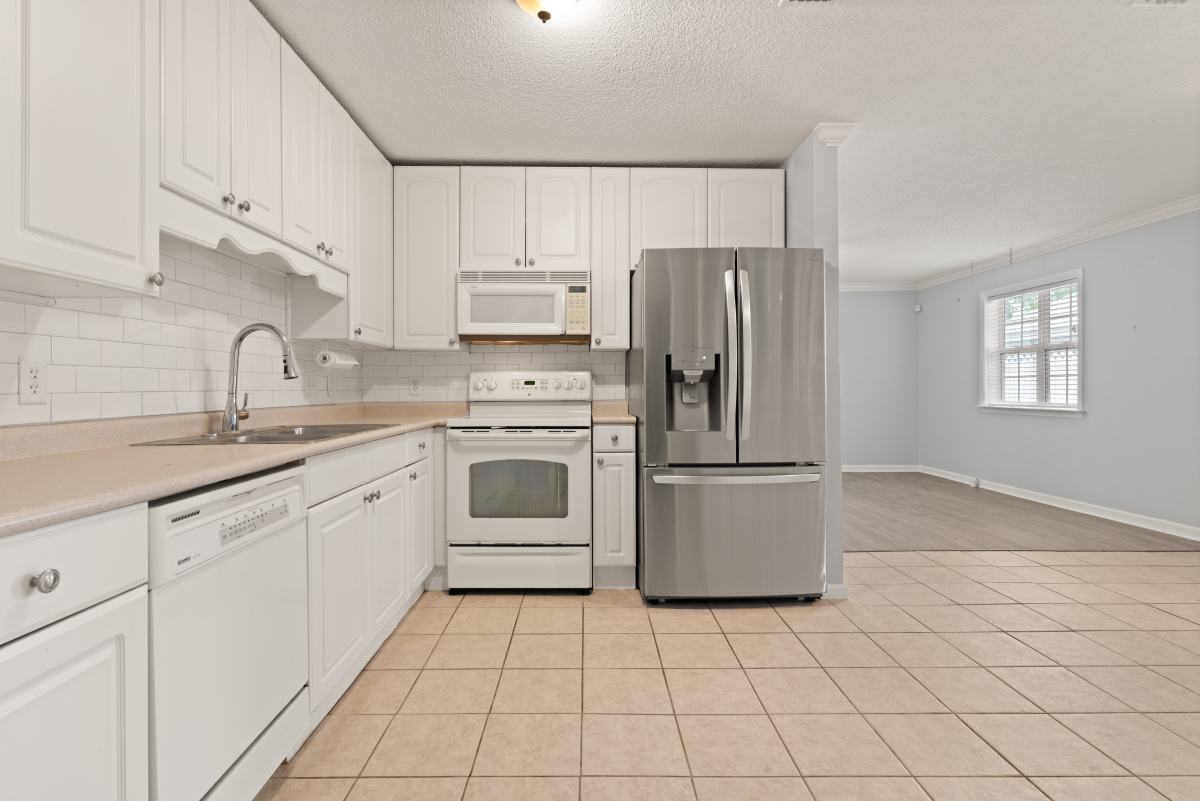 DSC03295 White kitchen with subway tile backsplash and stainless steel refrigerator in Glynn Haven home